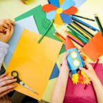 criação e da imaginação: vários papeis coloridos e um foquete de papel mais uma flor