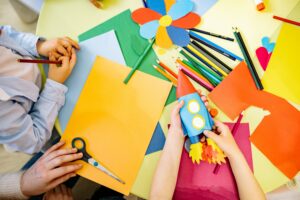 criação e da imaginação: vários papeis coloridos e um foquete de papel mais uma flor