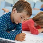 Aprender brincando: Imagem tem um menino loiro com uma blusa azul e em segundo plano uma menina loira de blusa rosa