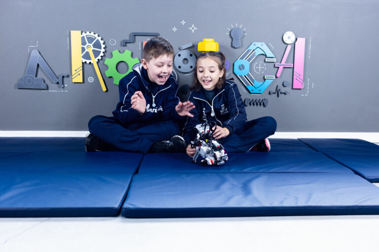 robótica para crianças: um menino e uma menina interagindo com um robô.