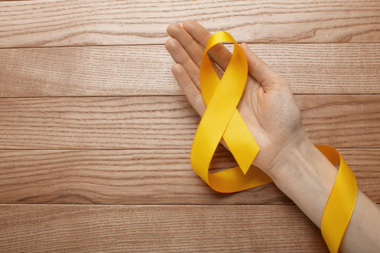 prevenção ao suicídio: uma mão segurando uma fita amarela.