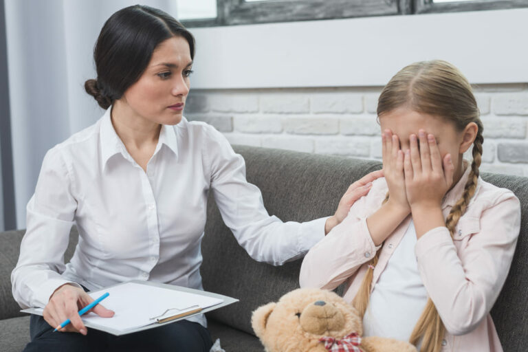 saúde mental nas escolas: uma psicologa acolhendo uma menina chorando.