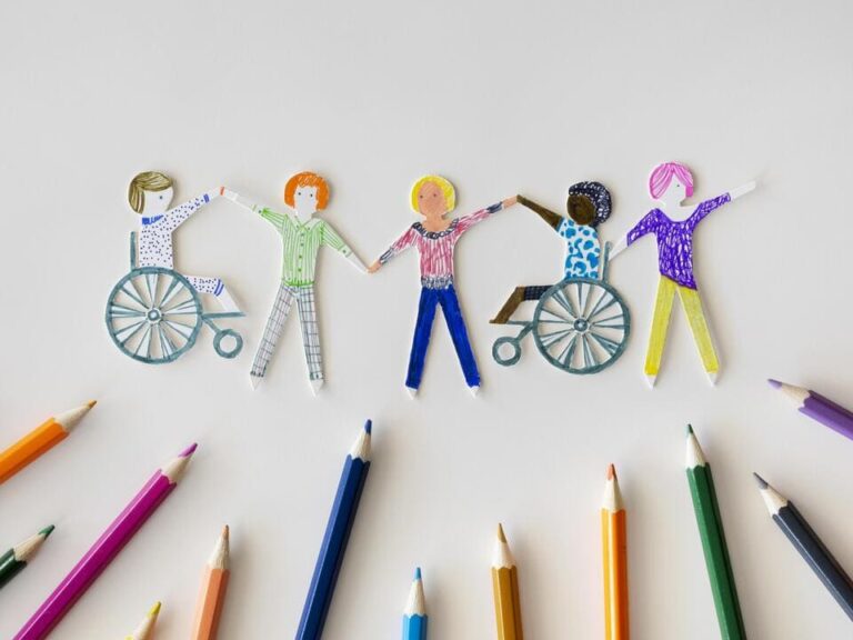 educação inclusiva: desenho de crianças em suas formas diversas de mão dadas e alguns lápis de cores em baixo.