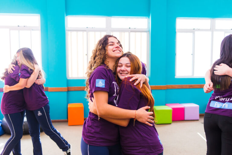 Duas meninas se abraçando e praticando a espiritualidade na escola dos colégios Maristas